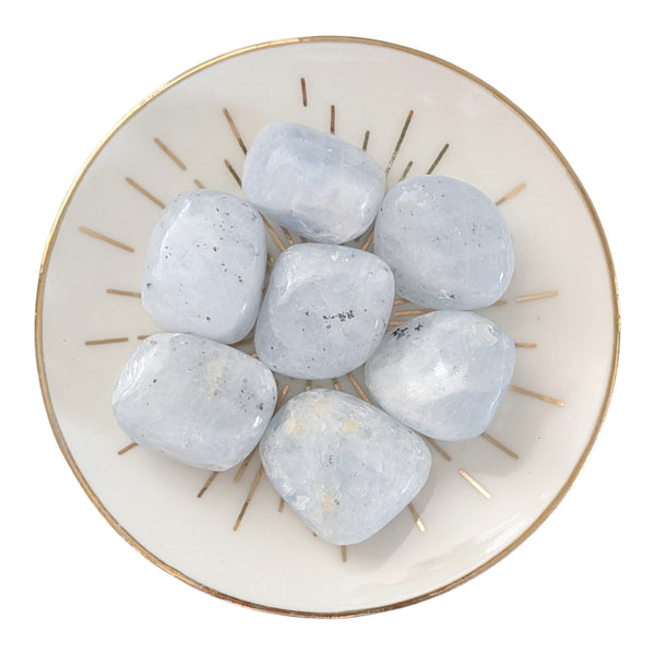 Blue Calcite tumblestones displayed on a small gold rimmed dish.