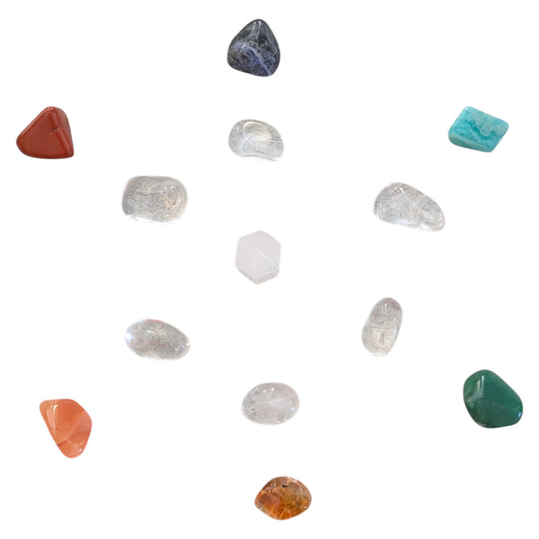Seven Chakra Crystal  Flower of Life Grid Set featuring a clear quartz point and clear quartz, blue sodalite, amazonite, green aventurine, citrine, carnelian and red jasper tumblestones. 