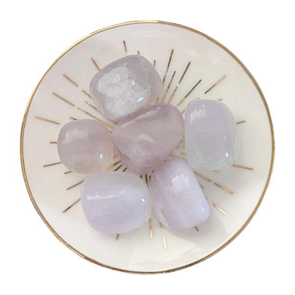 Pink Fluorite tumblestones displayed in a gold-rimmed crystal dish