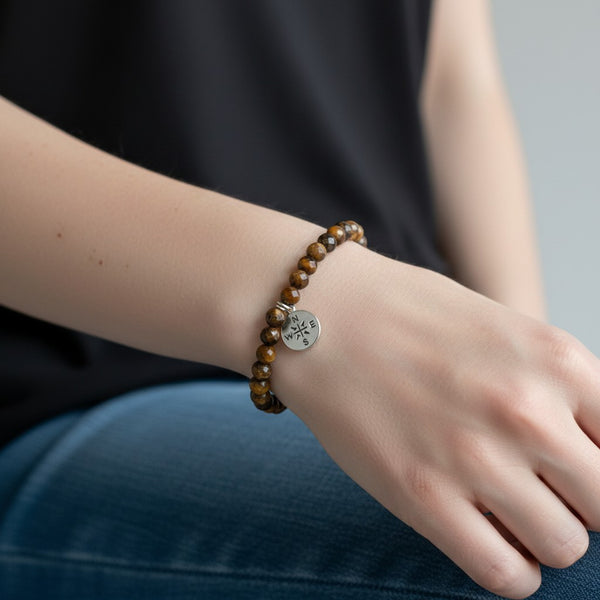 faceted tigers eye crystal beaded bracelet with 925 sterling silver compass charm attached. 